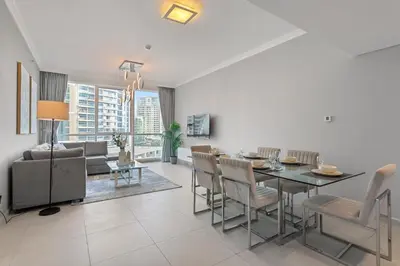 a dining room and living room with a table and chairs at Serene 2-bedroom Escape with Sea Steps Away in JBR in Dubai