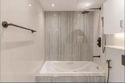 a white bath tub in a bathroom with a shower at AWS Holiday Homes - Style in Downtown in Dubai