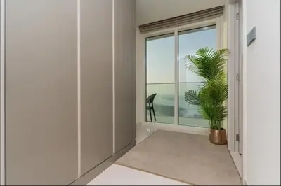a room with a large window and a plant at AWS Holiday Homes - Amazing Beachfront Stay in Dubai
