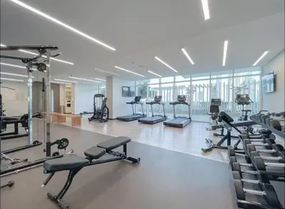 a gym with several treadmills and exercise bikes at AWS Holiday Homes - Amazing Beachfront Stay in Dubai