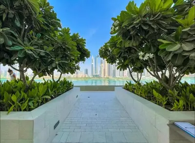 a walkway with trees and a view of the city at AWS Holiday Homes - Amazing Beachfront Stay in Dubai