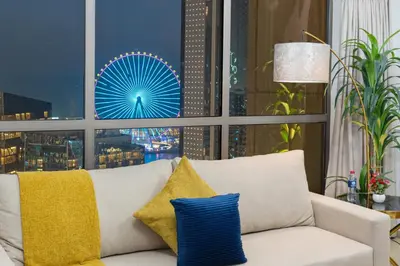 a white couch with yellow and blue pillows in front of a window at Dubai Eye & Sea View 2BR Marina & Beach Walk in Dubai