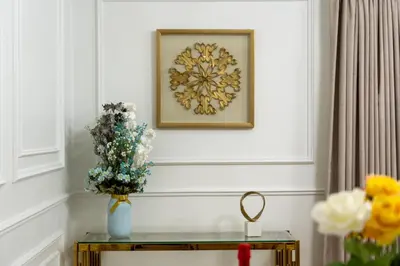 a table with a vase of flowers and a picture on a wall at Dubai Eye & Sea View 2BR Marina & Beach Walk in Dubai
