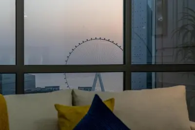 a view of a ferris wheel through a window at Dubai Eye & Sea View 2BR Marina & Beach Walk in Dubai