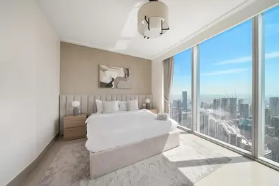 a bedroom with a large bed and a large window at FIRST CLASS 1BR Modern Luxury on High Floor in Dubai