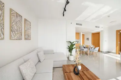 a living room with a white couch and a table at FIRST CLASS 1BR Modern Luxury on High Floor in Dubai