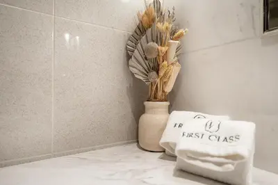 a towel sitting on a counter next to a vase with flowers at FIRST CLASS 1BR Modern Luxury on High Floor in Dubai