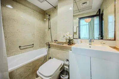 a bathroom with a tub and a toilet and a sink at Elegant 1 Bedroom in Botanica Tower Marina in Dubai