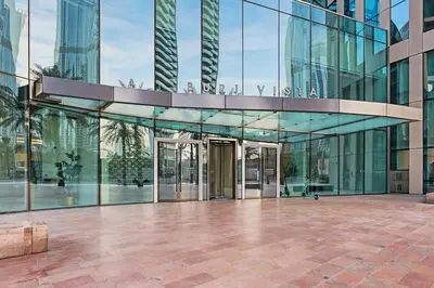a glass building with a revolving door at Burj Khalifa & Fountain From Your Balcony Near Dubai Mall & Metro in Dubai