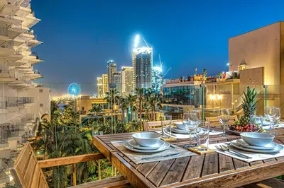 a table on a balcony with a view of a city at FIVE Palm Jumeirah Premier Apartments in Dubai