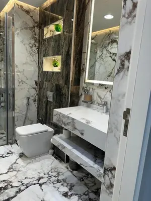 a marble bathroom with a toilet and a sink at Designer 1BR I Golf View I Comfortably Sleeps 4 in Dubai