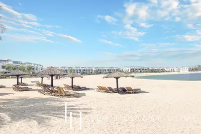 a group of chairs and umbrellas on a beach at LUX The Palm Island Shoreline Suite in Dubai