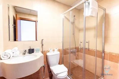 a bathroom with a toilet and a sink and a shower at Lovely Cozy Studio l Steps to JBR in Dubai