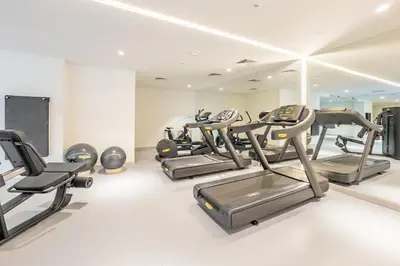 a gym with treadmills and ellipticals in a room at Pool View Studio with Balcony Close to Mall, Concept 7 Residences, Jumeirah Village Circle by Deluxe Holiday Homes in Dubai
