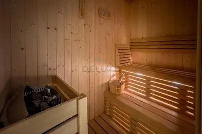 a wooden sauna with a bucket of logs in it at Pool View Studio with Balcony Close to Mall, Concept 7 Residences, Jumeirah Village Circle by Deluxe Holiday Homes in Dubai