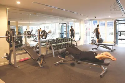 a man laying on a bench in a gym at Stylish 2BR Apt in Business Bay Burj & Creek Views in Dubai