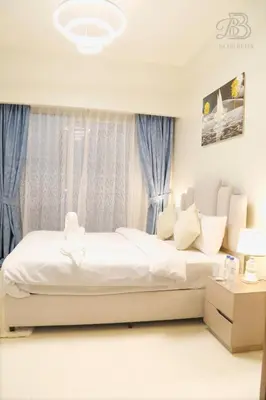 a bedroom with a white bed and a window at Stylish 2BR Apt in Business Bay Burj & Creek Views in Dubai