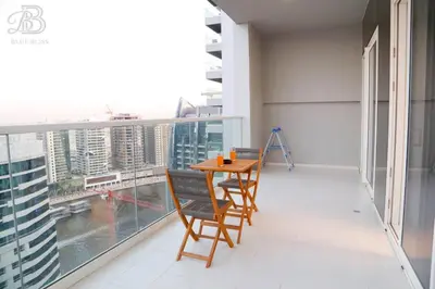 a balcony with a wooden table and chairs on it at Stylish 2BR Apt in Business Bay Burj & Creek Views in Dubai