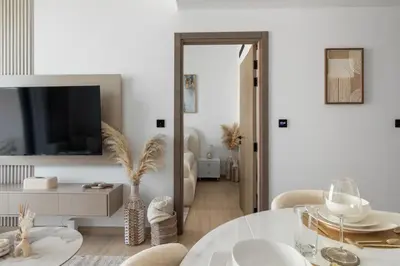 a living room with a table and a tv at Modern 1BR Apartment - JVC - WiFi - Pool - Gym in Dubai