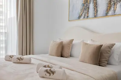 a bedroom with a white bed with white pillows at Modern 1BR Apartment - JVC - WiFi - Pool - Gym in Dubai