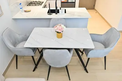 a white table and chairs with a vase of flowers on it at Stunning 1 Bdr luxury residence at JVC in Dubai