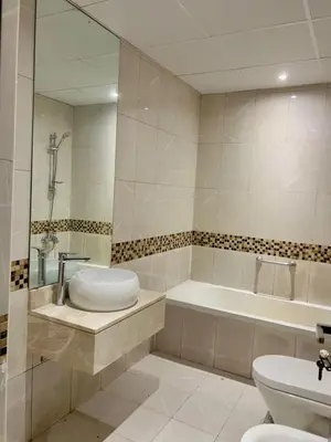 a bathroom with a tub and a toilet and a sink at Amiqa Homes DIP 1 in Dubai