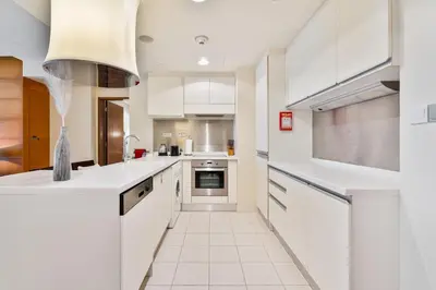 a kitchen with white counters and white appliances at Luxurious Studio with Burj Khalifa View Direct Dubai Mall Access - Kempinski Residence in Dubai