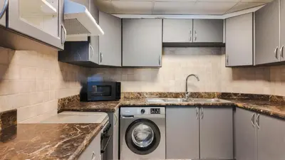 a kitchen with a washing machine and a sink at Sky High 2BR Stay Amazing Marina Views Near Metro & Mall in Dubai