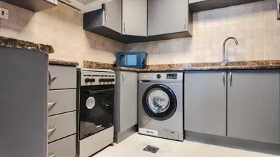 a kitchen with a washing machine and a washer at Sky High 2BR Stay Amazing Marina Views Near Metro & Mall in Dubai