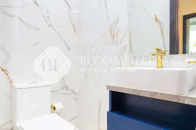 a bathroom with a white toilet and a sink at Bloomfields Hidden Gem 1Br with Private Pool in Dubai