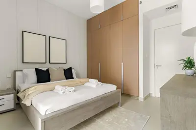 a bedroom with a bed with two towels on it at Silkhaus Chic 1BR in Creek Beach Grove with Pool view in Dubai