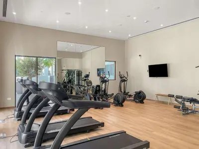 a gym with several exercise bikes and a mirror at Silkhaus Chic 1BR in Creek Beach Grove with Pool view in Dubai