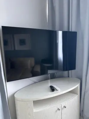 a tv on top of a table with a remote control at Cozy 1BR, 2Min to Dubai Mall in Dubai