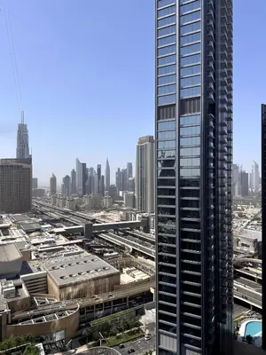 a view of a city with a tall skyscraper at Cozy 1BR, 2Min to Dubai Mall in Dubai