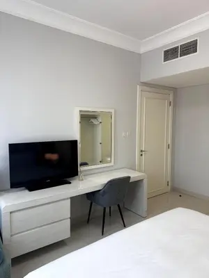 a desk with a television and a chair in a room at Cozy 1BR, 2Min to Dubai Mall in Dubai