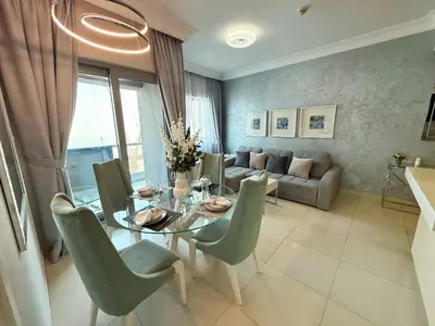 a living room with a glass table and chairs at Stylish 1BR, 2Min to Dubai Mall in Dubai