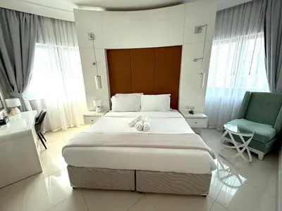 a bedroom with a large bed and a chair at Stylish 1BR, 2Min to Dubai Mall in Dubai