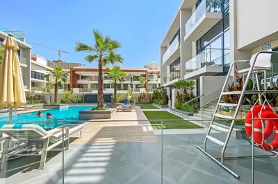 a swimming pool with chairs and a volley ball at Stylish Stay in the Heart of JVC in Dubai