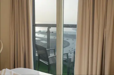 a room with a window with a view of the ocean at 49 -Elegant Princess Tower Family Apartment with Palm View, Balcony & Pool in Dubai