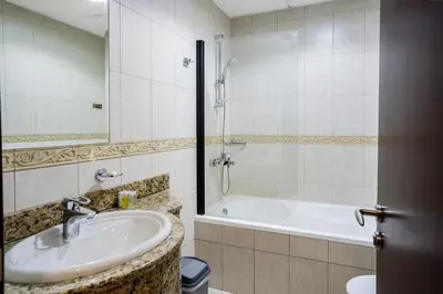 a bathroom with a sink and a bath tub at 49 -Elegant Princess Tower Family Apartment with Palm View, Balcony & Pool in Dubai