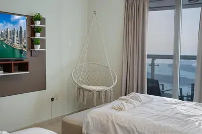 a bedroom with a hanging chair and a bed at 49 -Elegant Princess Tower Family Apartment with Palm View, Balcony & Pool in Dubai