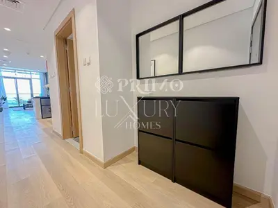 a living room with a tv on a wall at Comfy 1-Bedroom Apartment at Blue Wave - Liwan in Dubai