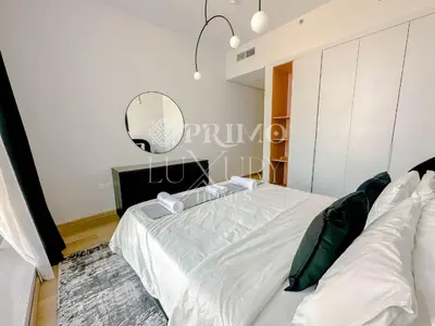 a bedroom with a large bed and a mirror at Comfy 1-Bedroom Apartment at Blue Wave - Liwan in Dubai