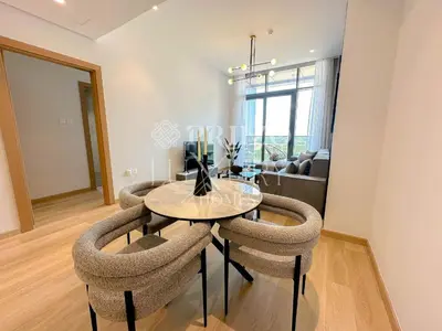 a dining room with a table and two chairs at Comfy 1-Bedroom Apartment at Blue Wave - Liwan in Dubai