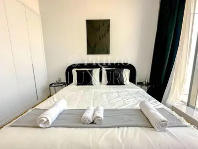 a bedroom with a bed with towels on it at Comfy 1-Bedroom Apartment at Blue Wave - Liwan in Dubai
