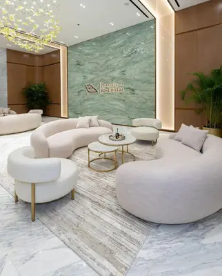 a lobby with white couches and chairs and a table at Elegant 2br Jvc Private Pool, Balcony & Parking in Dubai