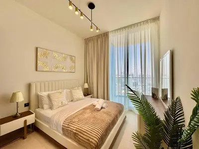 a bedroom with a bed and a large window at Elegant 2br Jvc Private Pool, Balcony & Parking in Dubai