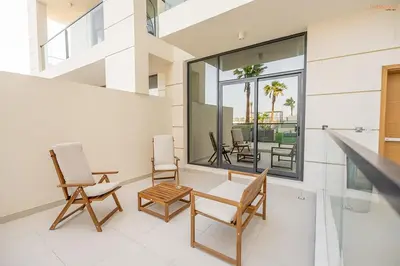 a living room with two chairs and a table at Bnbeyond's Sassy Studio with Expansive Balcony in Dubai