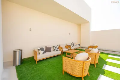 a living room with a couch and chairs and grass at Bnbeyond's Sassy Studio with Expansive Balcony in Dubai