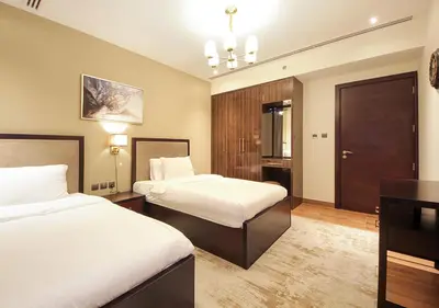 a hotel room with two beds and a desk at Stylish 2BR Downtown Apartment Burj & Mall Nearby in Dubai